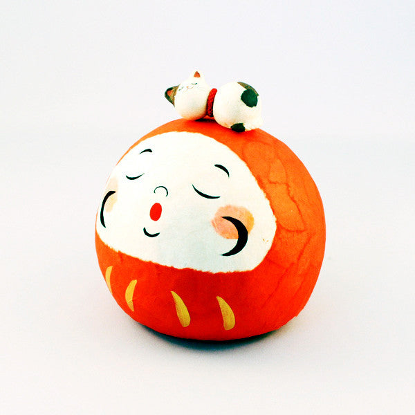 Sleeping cat on daruma